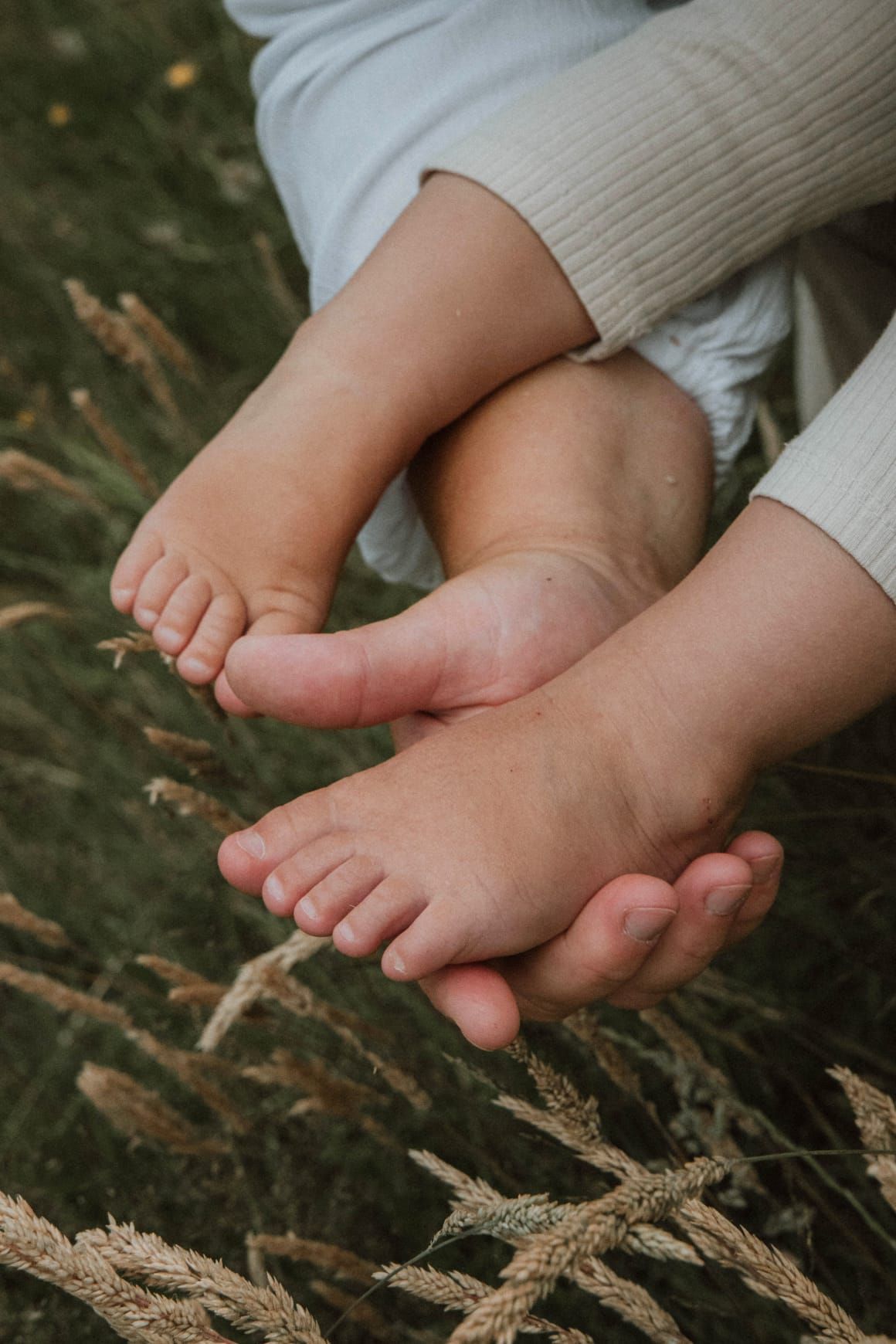 Babyfüße in der Hand der Mutter